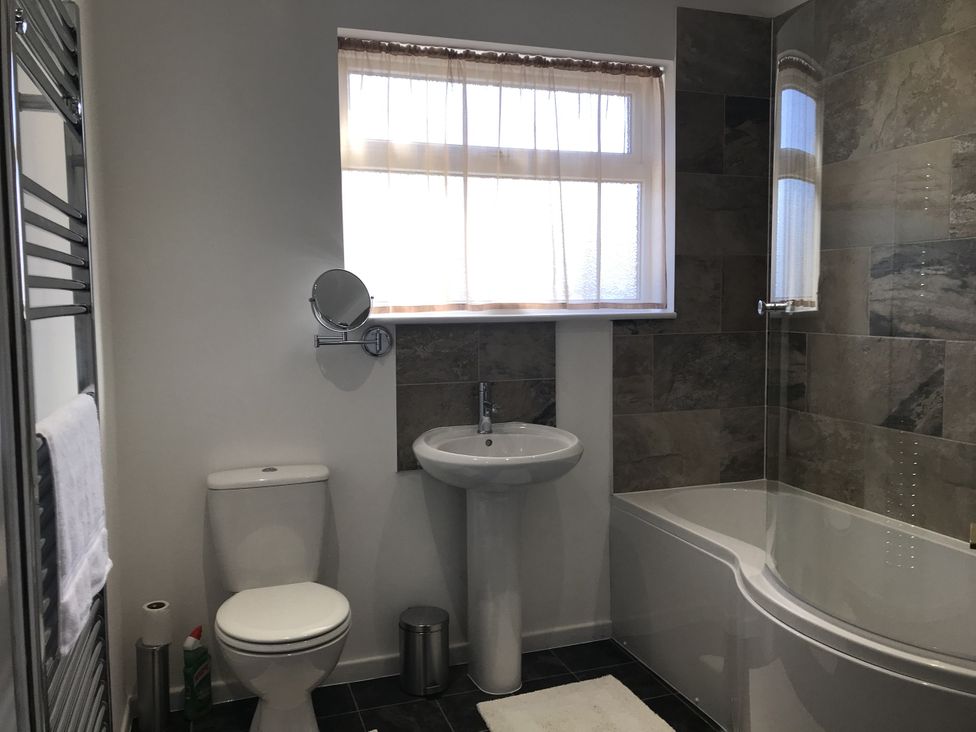 A bathroom with a sink, toilet, and bathtub at Lavender Harmony House in Swindon