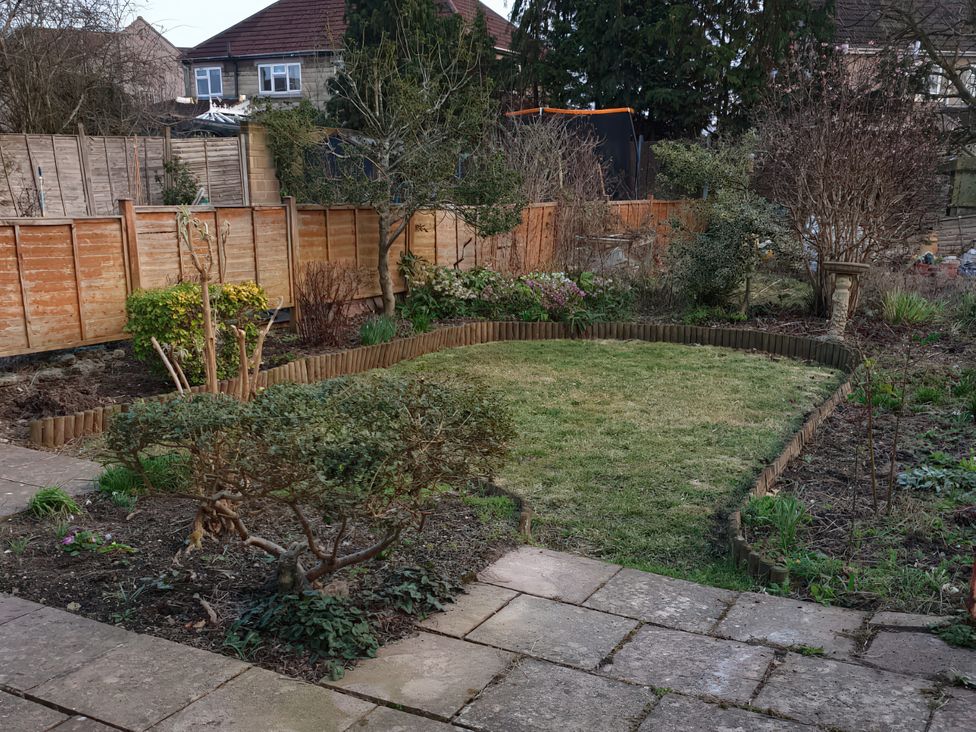 A garden with grass and flowerbeds at Lavender Harmony House in Swindon