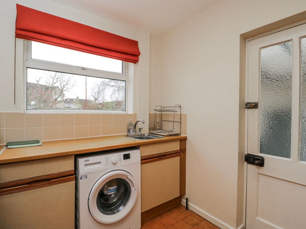 A laundry room with a washing machine and sink at Lavender Harmony House in Swindon