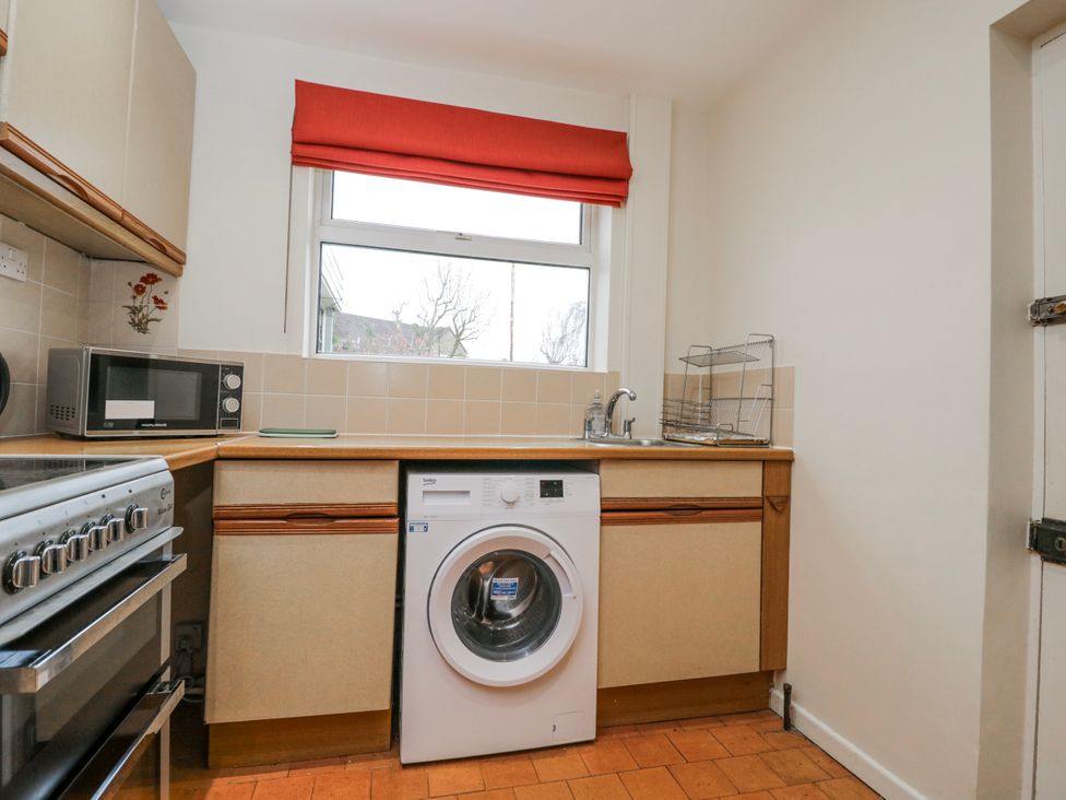 A kitchen with a washing machine and microwave at Lavender Harmony House in Swindon