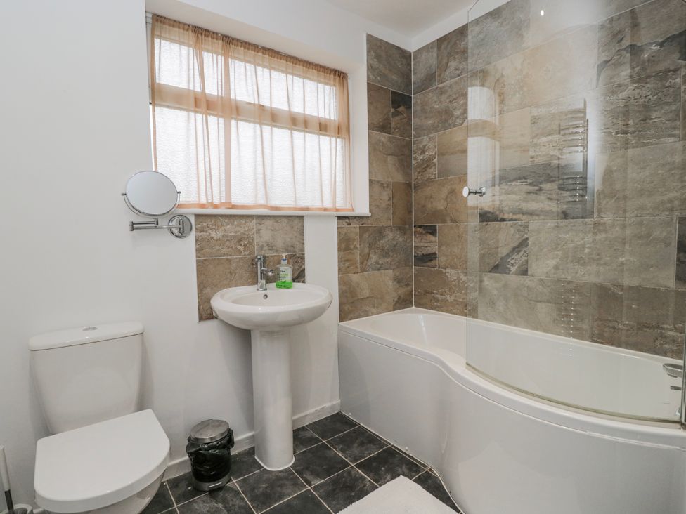 A bathroom with a toilet, sink, and bathtub at Lavender Harmony House in Swindon