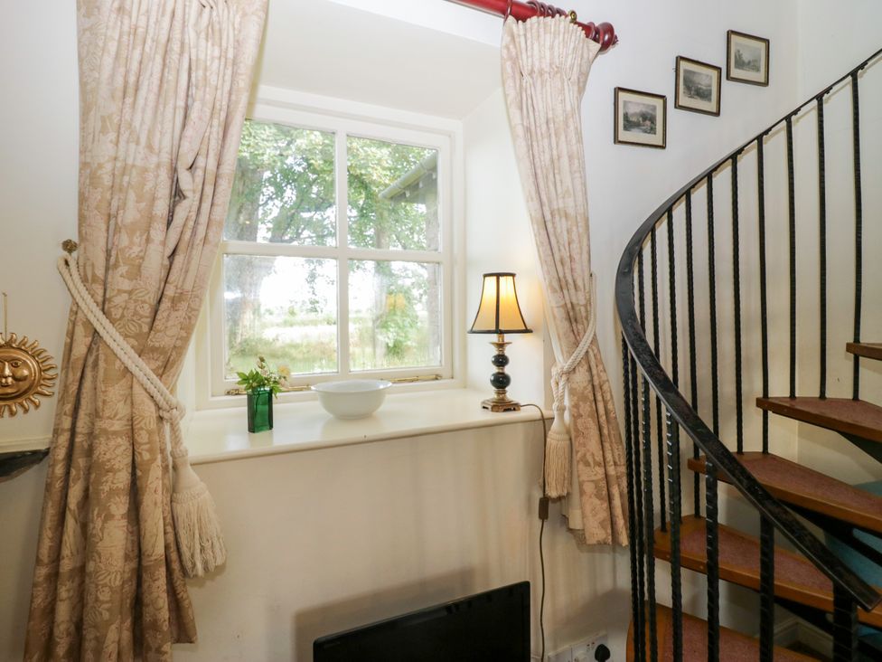 A staircase with a window and lamp at Longlands Milkmaid's Parlour Cartmel near Grange-over-Sands