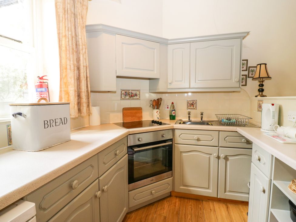 A kitchen with cabinets, sink, and appliances at Longlands Milkmaid's Parlour in Cartmel near Grange-over-Sands