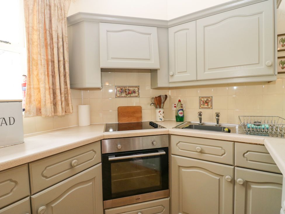 A kitchen with cabinets and appliances at Longlands Milkmaid's Parlour in Cartmel near Grange-over-Sands