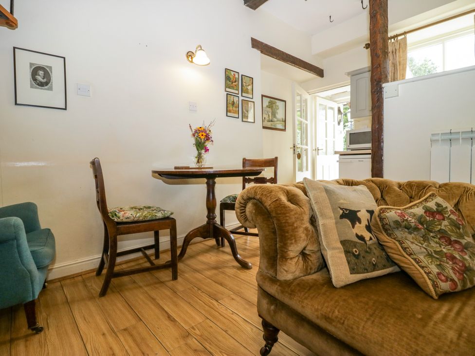 A living room with a sofa and dining table at Longlands Milkmaid's Parlour Cartmel near Grange-over-Sands