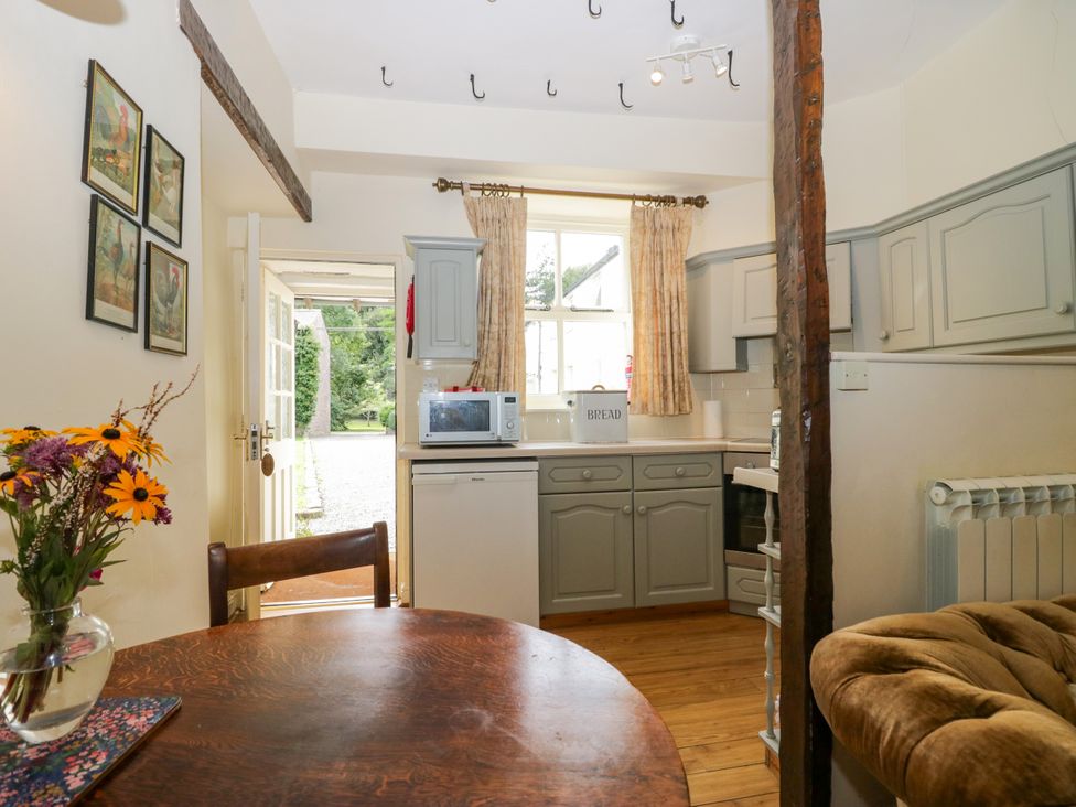 A kitchen with a table and chairs at Longlands Milkmaid's Parlour Cartmel near Grange-over-Sands