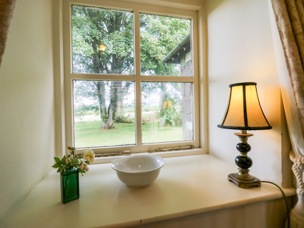 A kitchen window with a bowl and a lamp at Longlands Milkmaid's Parlour in Cartmel near Grange-over-Sands