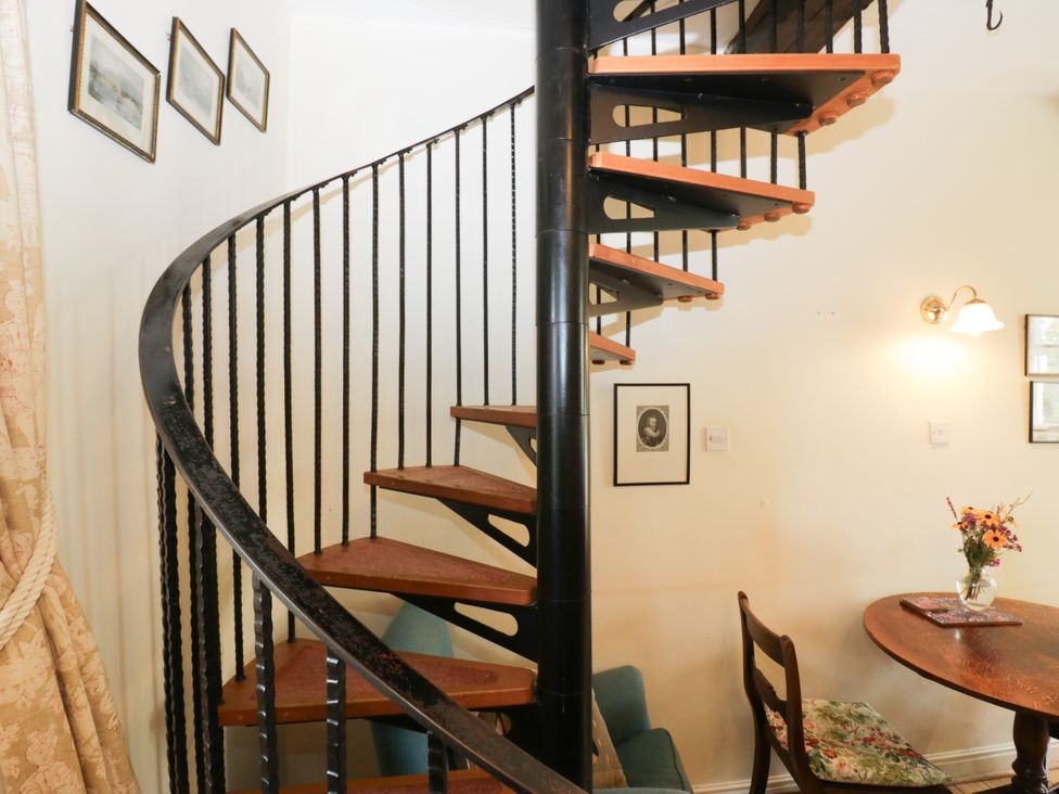 A spiral staircase with pictures on the wall at Longlands Milkmaid's Parlour, Cartmel near Grange-over-Sands