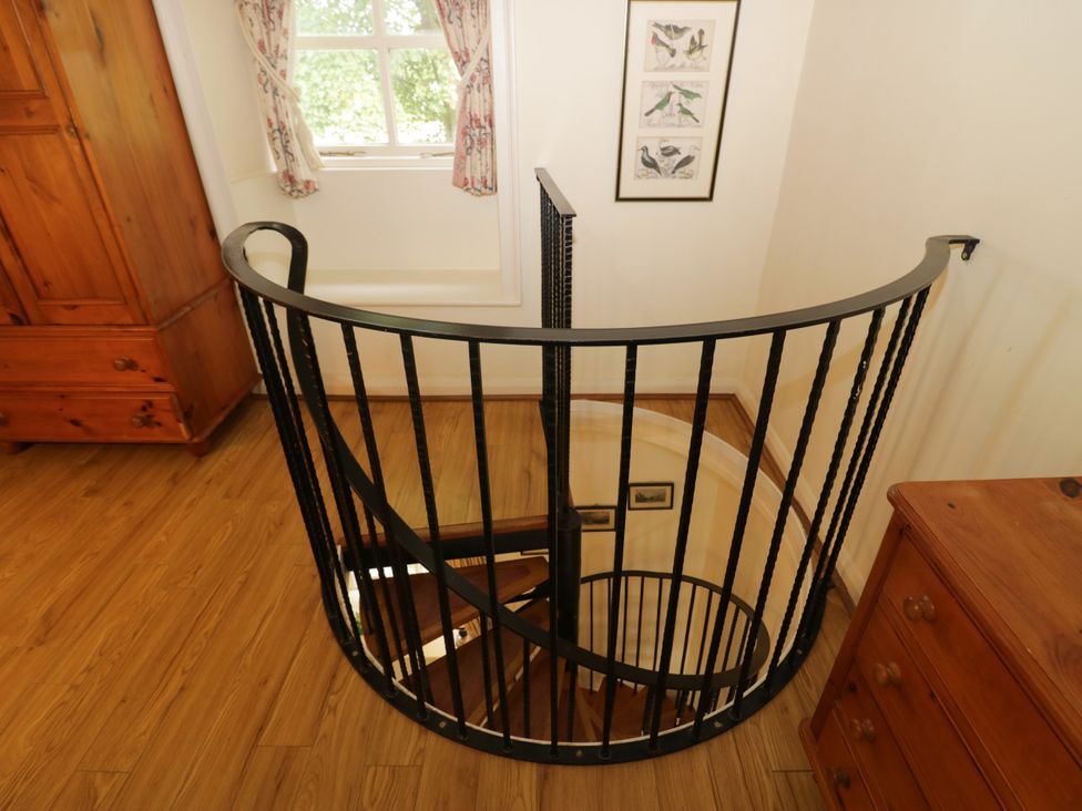 A spiral staircase with wooden floor and window at Longlands Milkmaid's Parlour, Cartmel near Grange-over-Sands