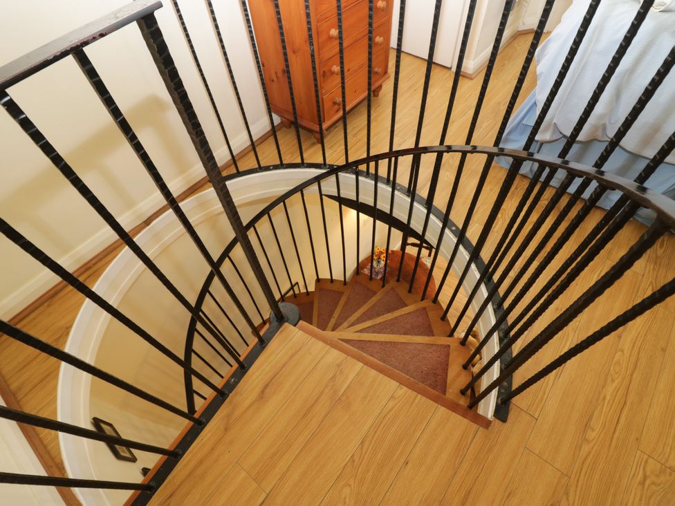 A spiral staircase leading down with wooden flooring at Longlands Milkmaid's Parlour in Cartmel near Grange-over-Sands
