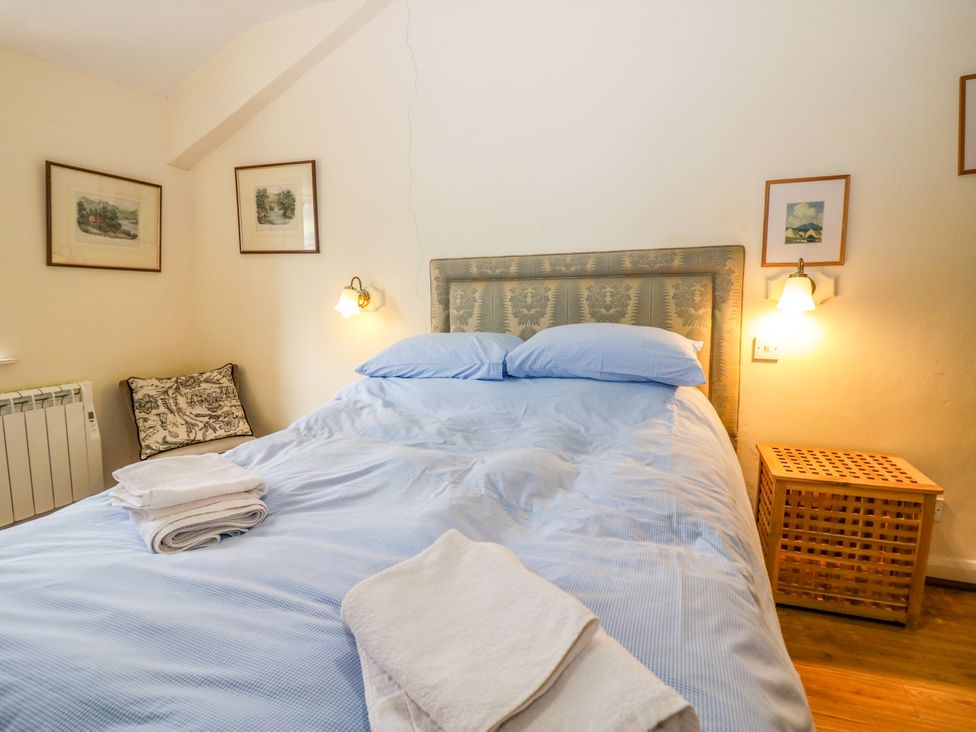 A bedroom with a bed and framed art at Longlands Milkmaid's Parlour Cartmel near Grange-over-Sands