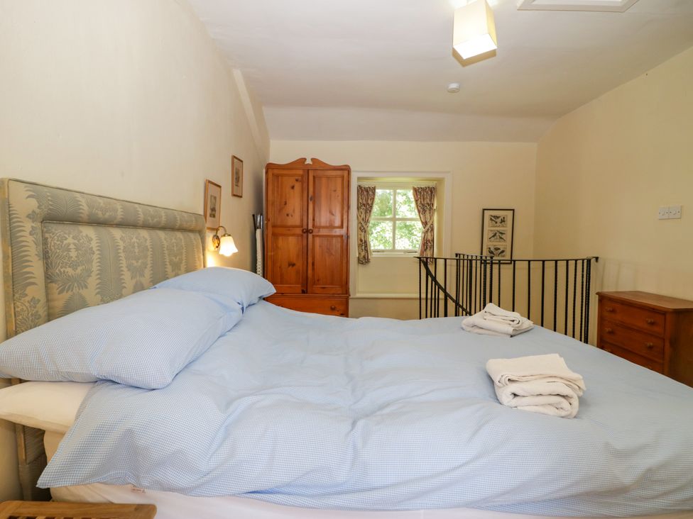 A bedroom with a bed and wardrobe at Longlands Milkmaid's Parlour in Cartmel near Grange-over-Sands