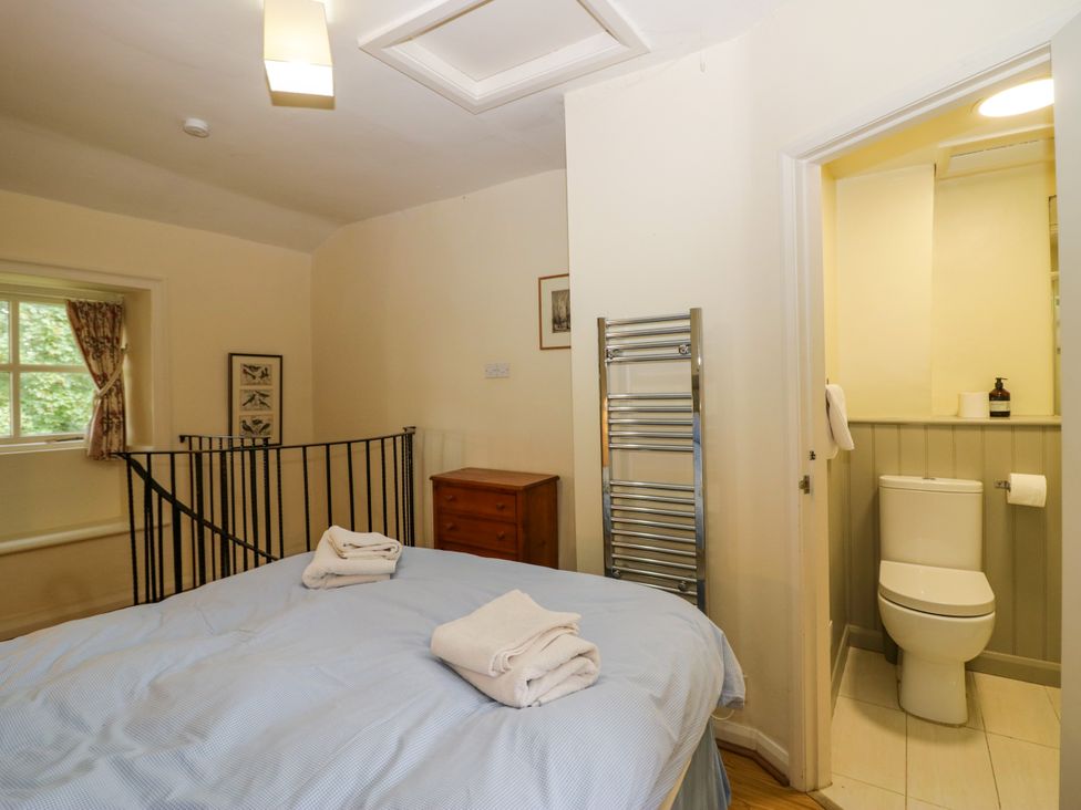 A bedroom with a bed and adjoining bathroom at Longlands Milkmaid's Parlour in Cartmel near Grange-over-Sands