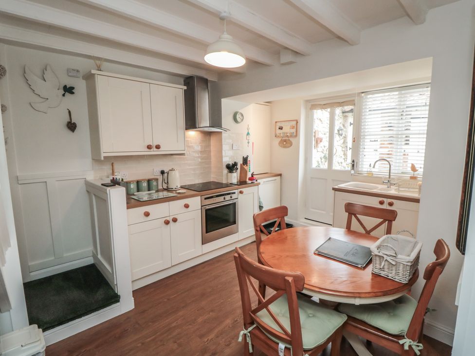A kitchen with countertops and a dining table at Dove Cottage in Pickering