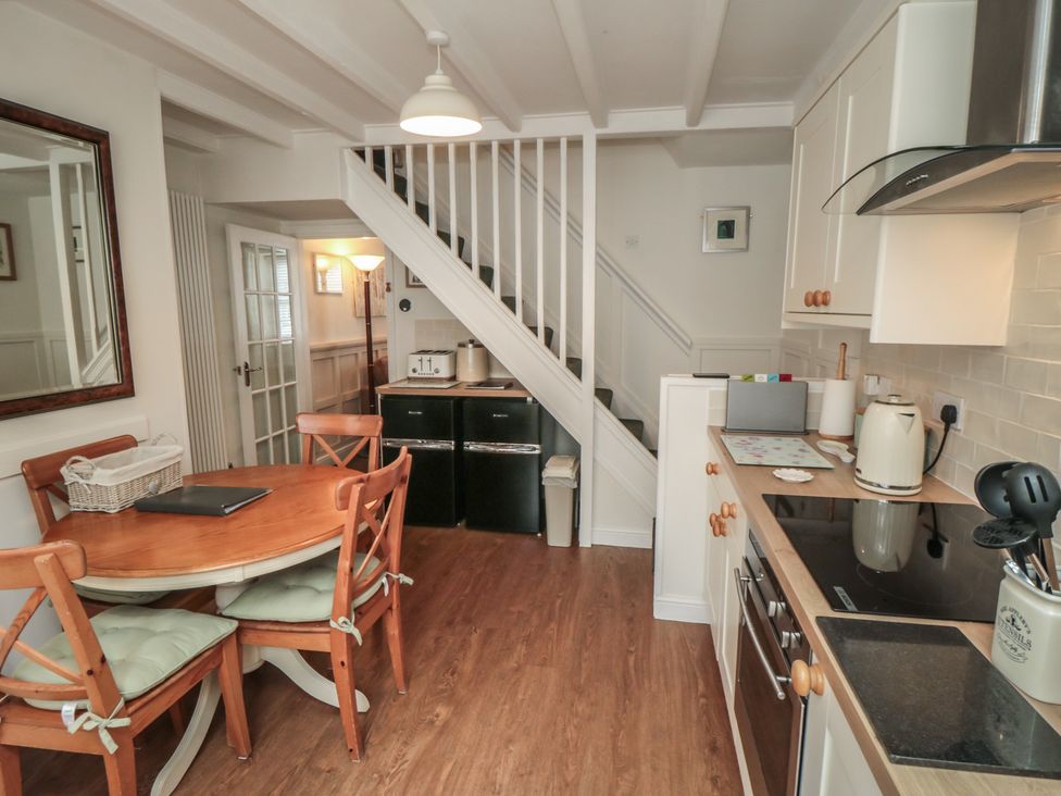 A kitchen with a dining table and stairs at Dove Cottage in Pickering