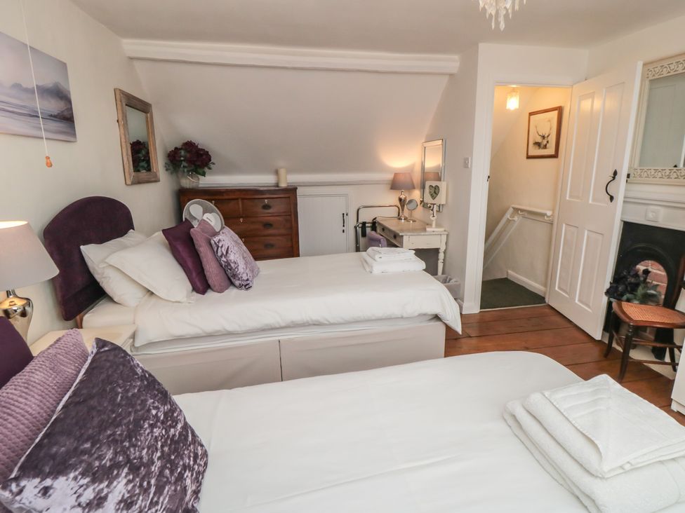 A bedroom with two beds and a mirror at Dove Cottage in Pickering
