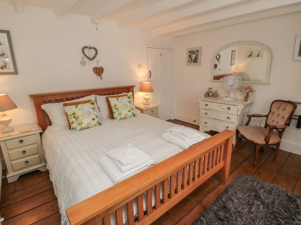 A bedroom with a bed and nightstands at Dove Cottage in Pickering