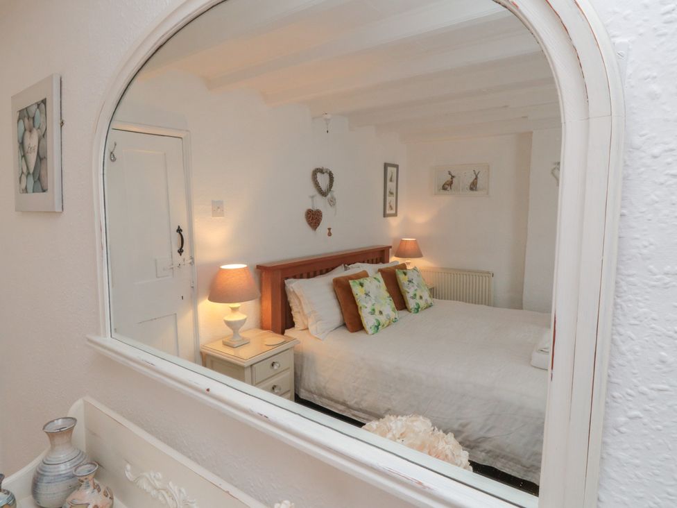 A bedroom with a bed and decorative items at Dove Cottage in Pickering