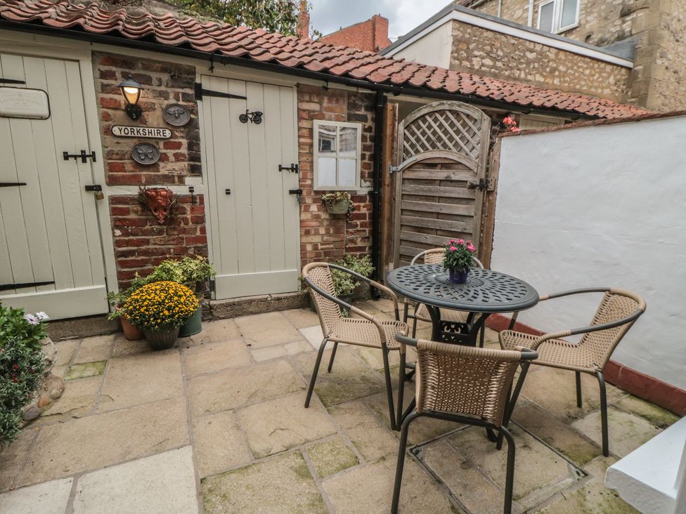 A patio with a table and chairs at Dove Cottage in Pickering
