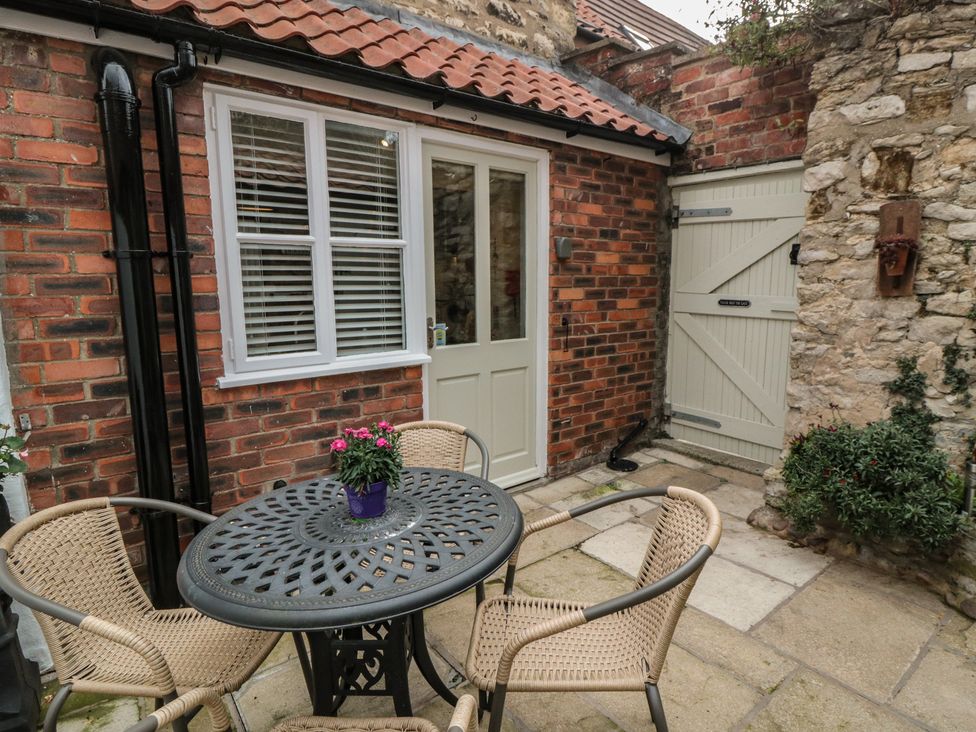 A patio area with a table and chairs at Dove Cottage in Pickering