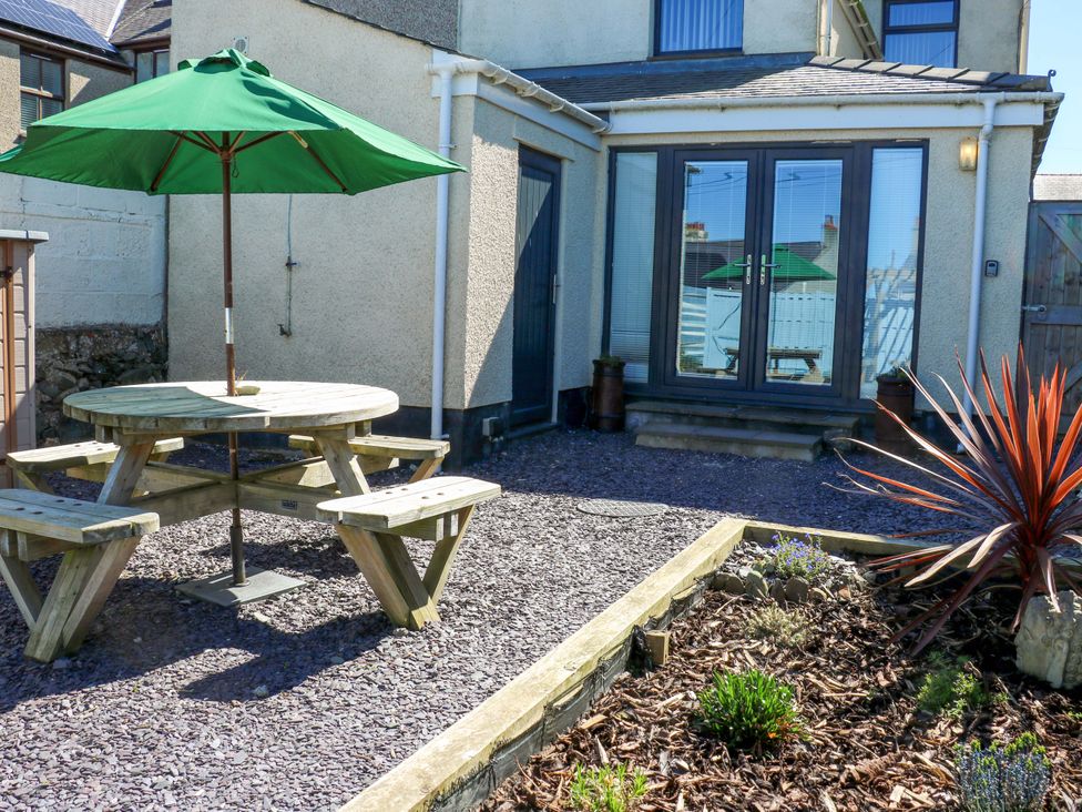 An outdoor area with a picnic table and umbrella at Rhiwlas Rhosneigr