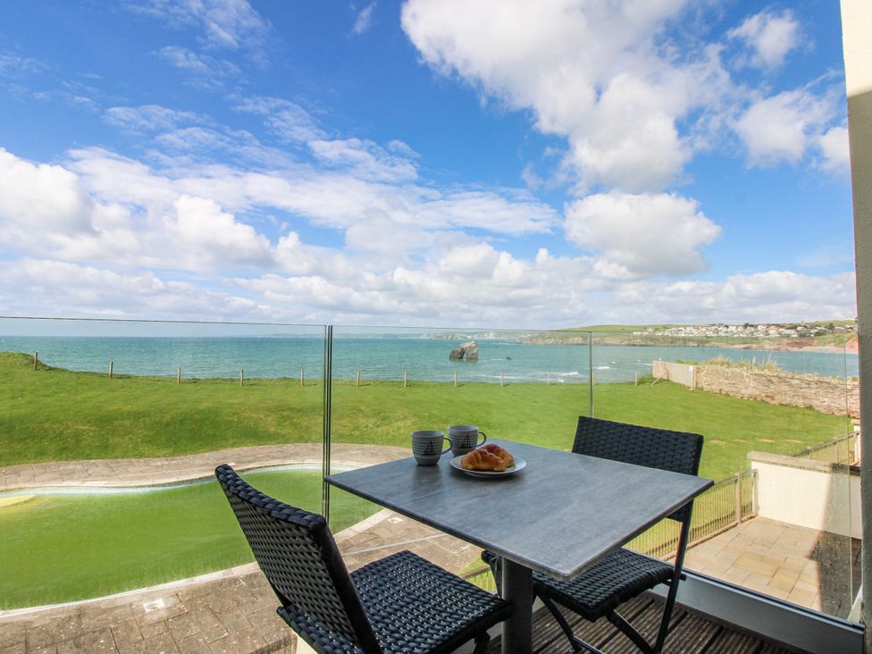 A table with chairs and pastries overlooking the sea at 7 Ocean's Edge Thurlestone