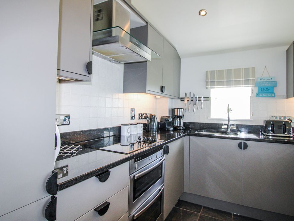 A kitchen with cabinets and appliances at 7 Ocean's Edge Thurlestone