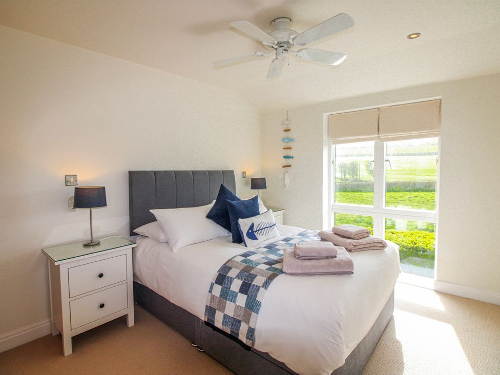 A bedroom with a bed and bedside table at 7 Ocean's Edge in Thurlestone