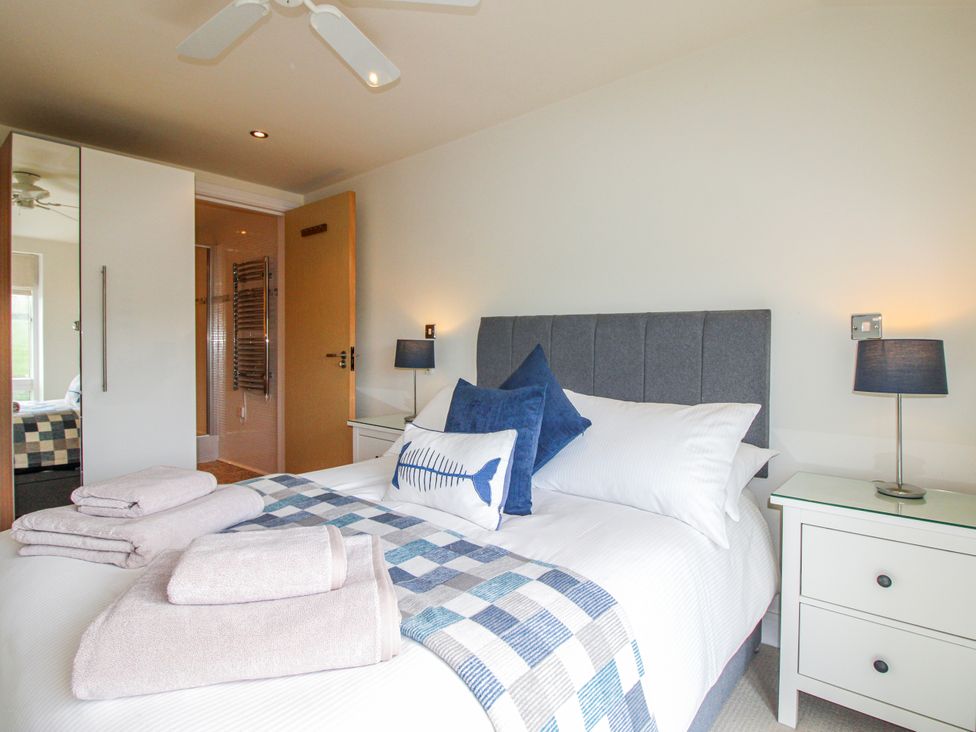 A bedroom with a bed and bedside table at 7 Ocean's Edge in Thurlestone