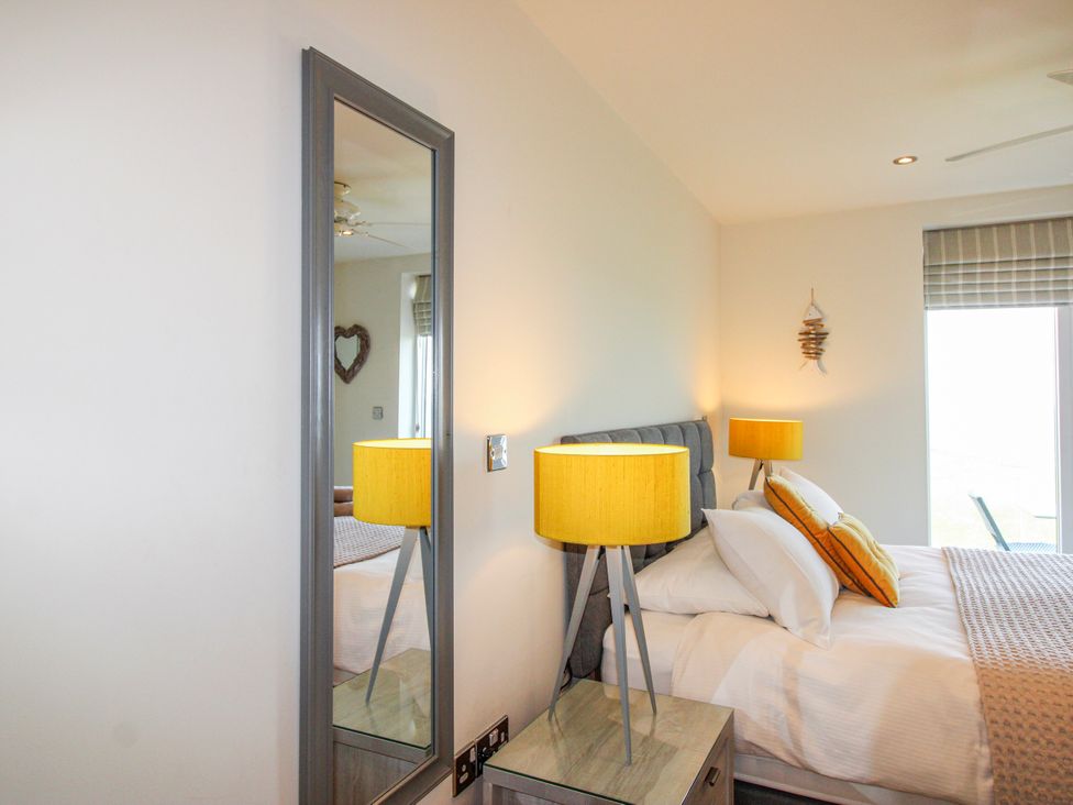 A bedroom with a bed and lamps at 7 Ocean's Edge Thurlestone