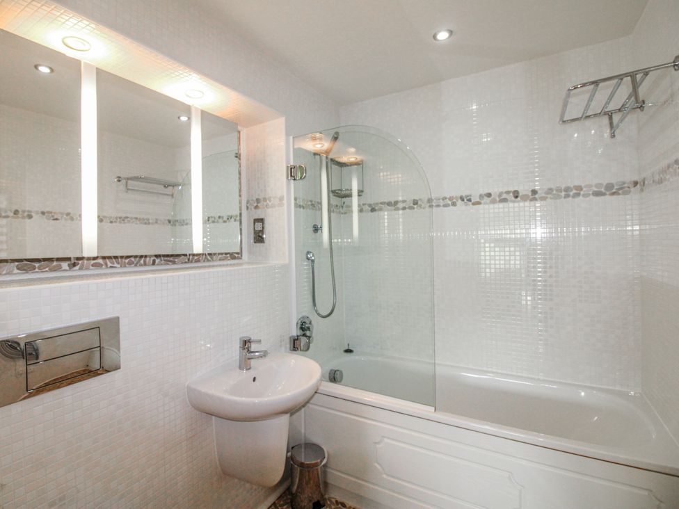 A bathroom with a bathtub and sink at 7 Ocean's Edge Thurlestone