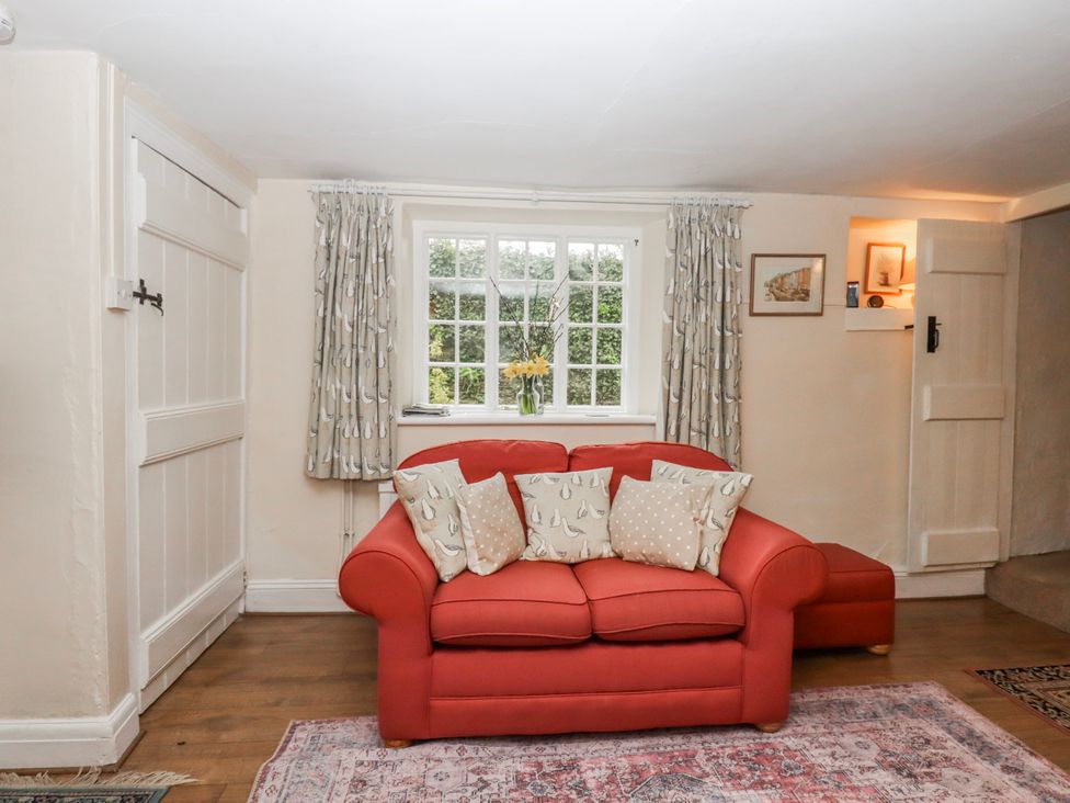 A living room with a sofa and pillows at Yew Tree Cottage in Stoke Fleming