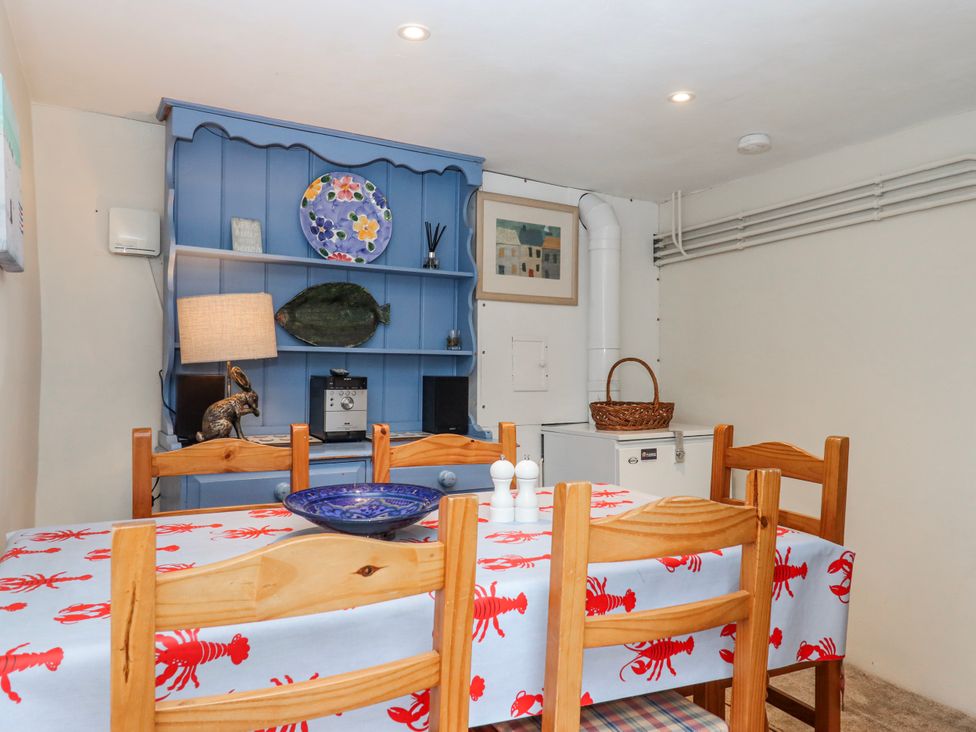 A dining room with a table and chairs at Yew Tree Cottage Stoke Fleming