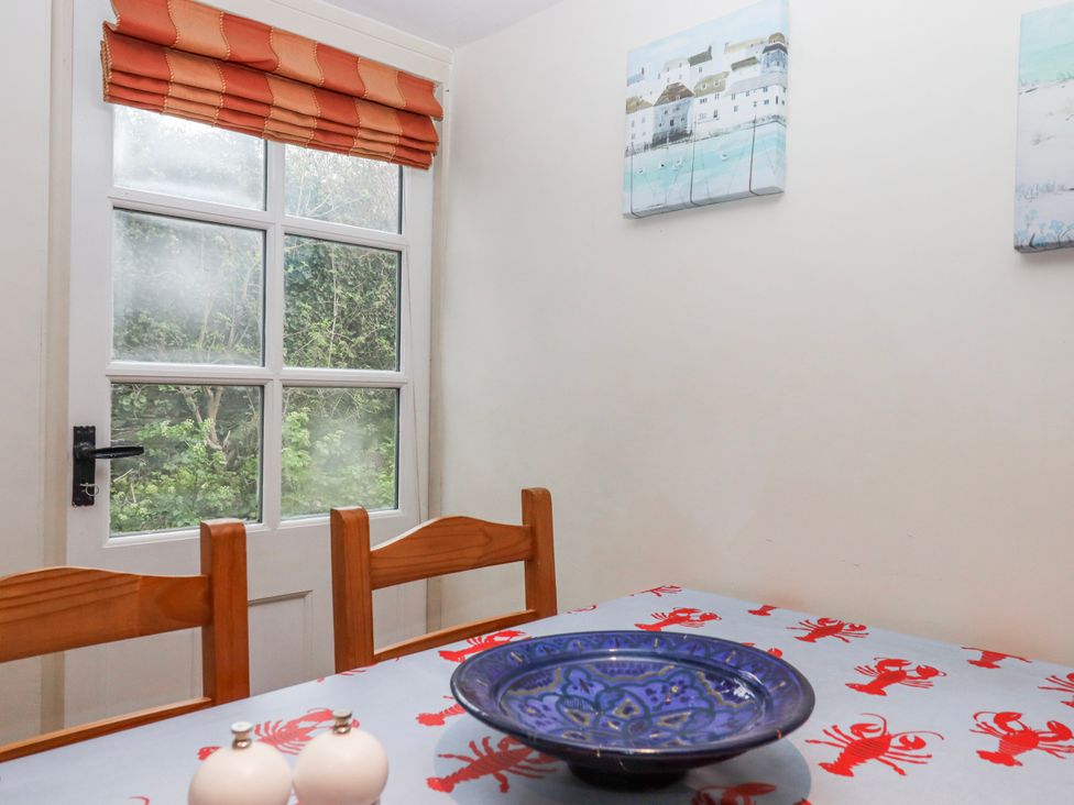 A dining room with a table and bowl at Yew Tree Cottage Stoke Fleming