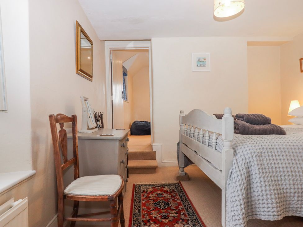A bedroom with a bed and desk at Yew Tree Cottage Stoke Fleming