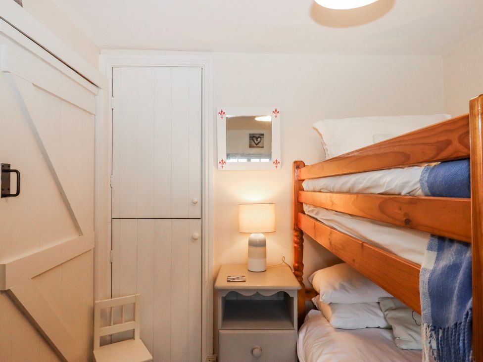 A bedroom with a bunk bed and a lamp at Yew Tree Cottage Stoke Fleming
