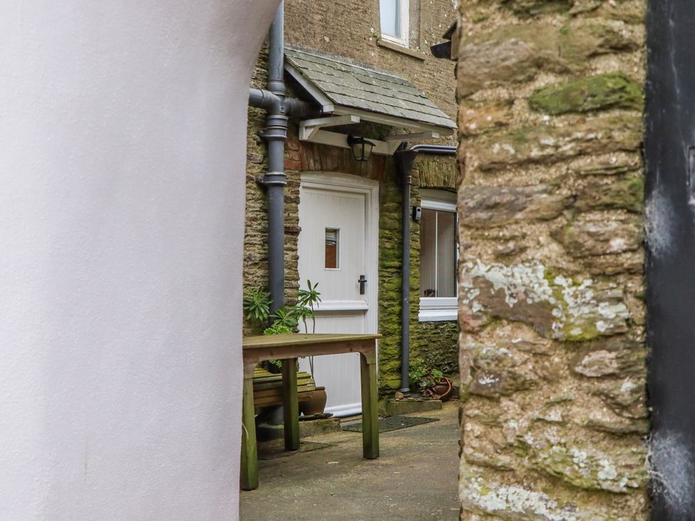 An outdoor area with a door and table at Yew Tree Cottage in Stoke Fleming