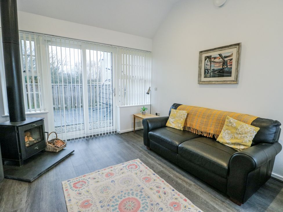 A living room with a sofa and wood stove at 2 Mountain View, Talwrn near Llangefni