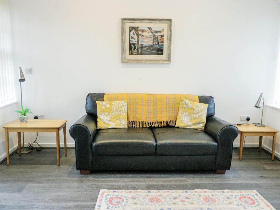 A living room with a sofa and side tables at 2 Mountain View in Talwrn near Llangefni