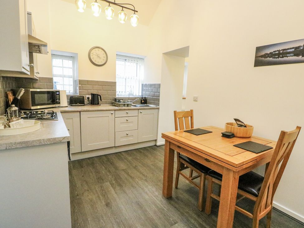 A kitchen with appliances and a dining table at 2 Mountain View Talwrn near Llangefni
