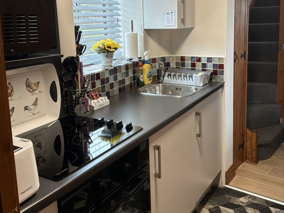 A kitchen with a sink and stove at Ysgubor Ddegwm Bach in Llanddona near Beaumaris