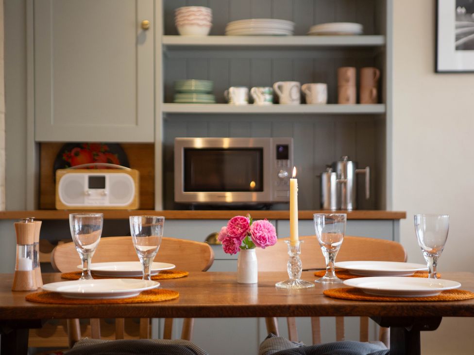 A dining room with a table set for a meal at Newstead Farmhouse in East Chiltington near Lewes, Sussex