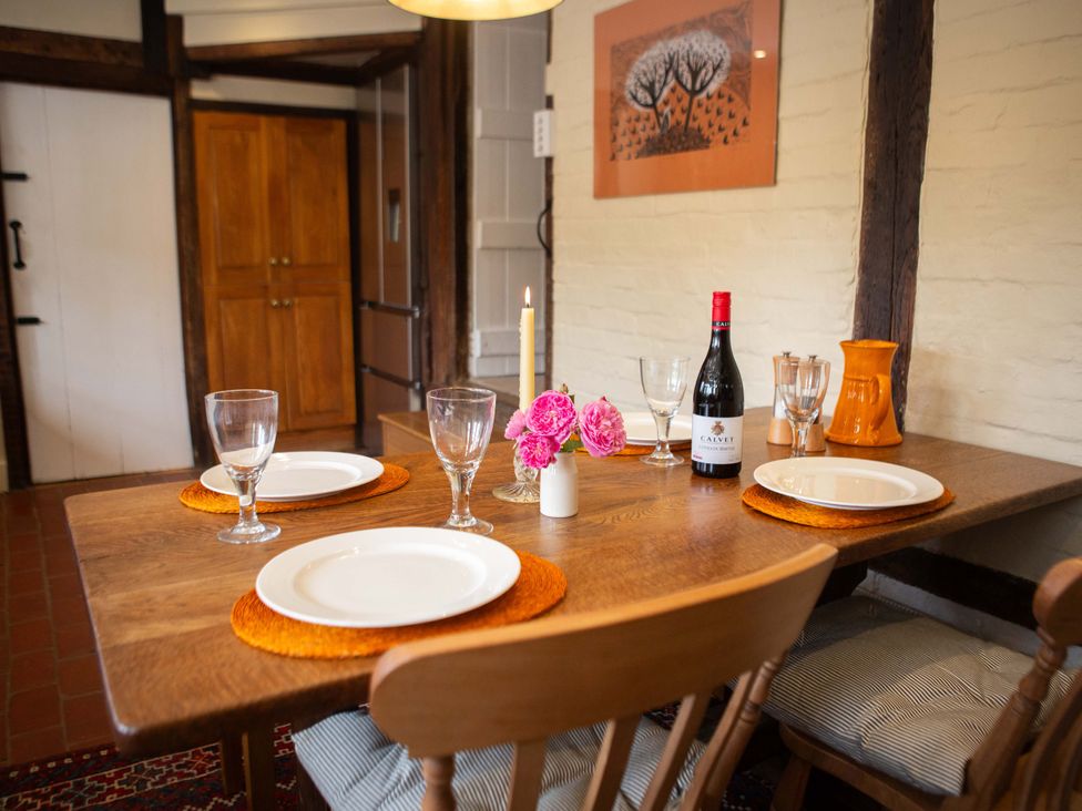 A dining room with a table set for dinner at Newstead Farmhouse in East Chiltington near Lewes, Sussex