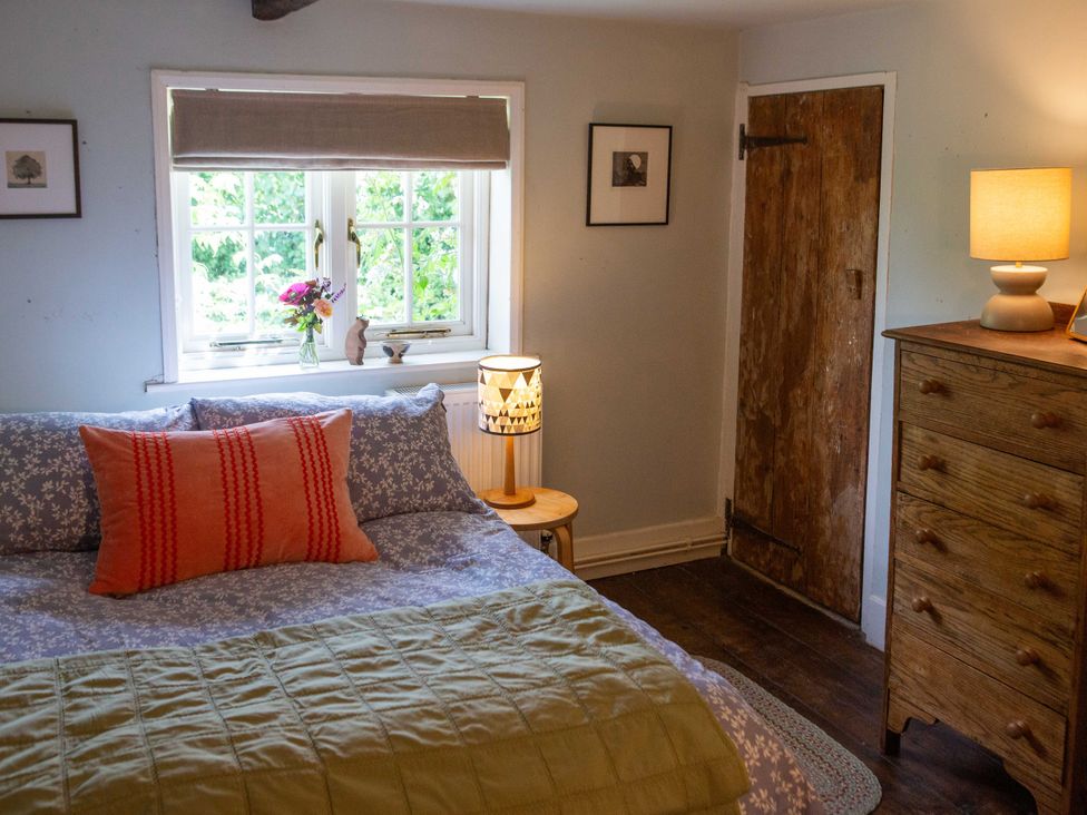 A bedroom with a bed and window at Newstead Farmhouse in East Chiltington near Lewes, Sussex