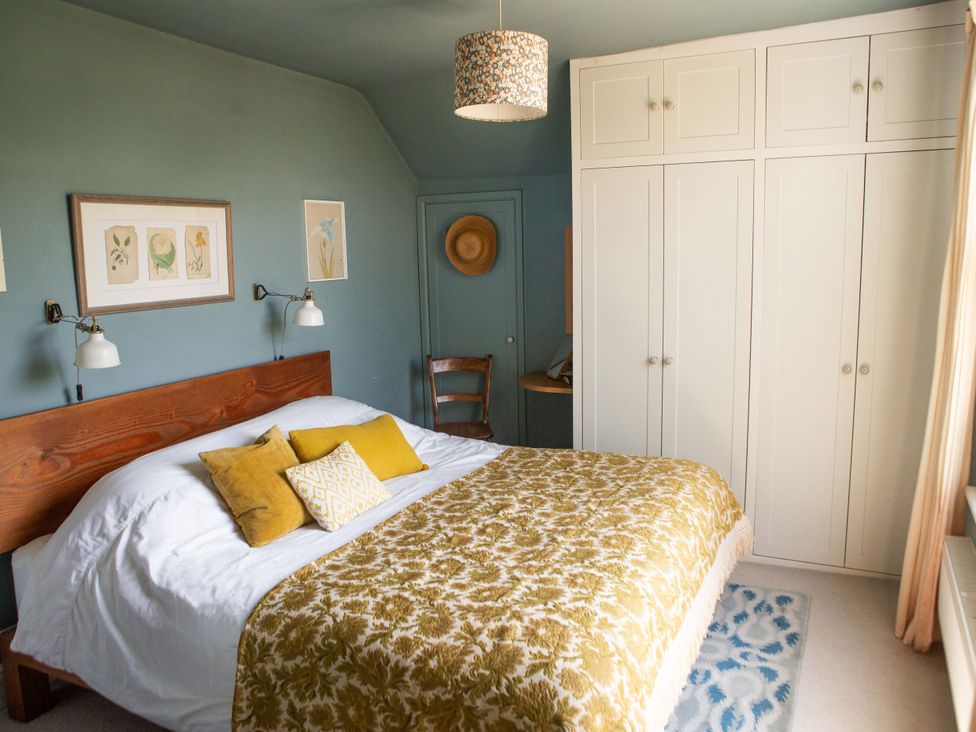 A bedroom with a bed, wardrobe, and lamps at Newstead Farmhouse, East Chiltington near Lewes, Sussex