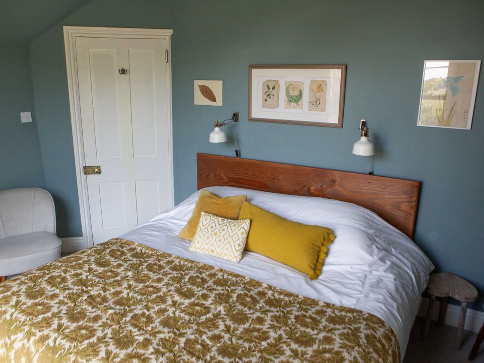 A bedroom with a bed and wall art at Newstead Farmhouse in East Chiltington near Lewes, Sussex