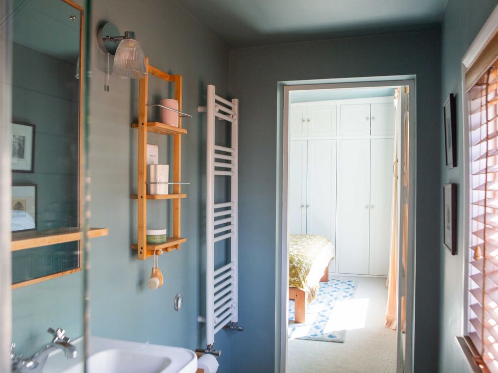 A bathroom with a tub and shelf at Newstead Farmhouse in East Chiltington near Lewes, Sussex