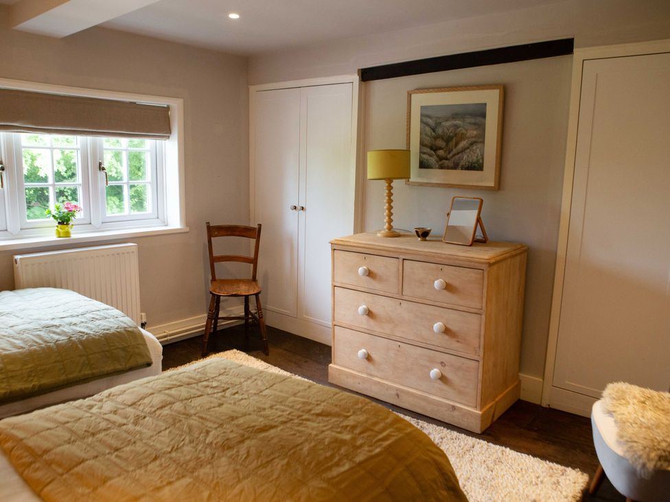 A bedroom with two beds and a dresser at Newstead Farmhouse in East Chiltington near Lewes, Sussex