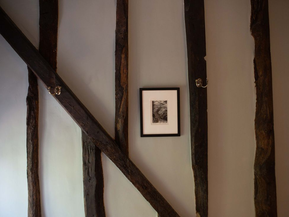 A wall with beams and a framed photograph at Newstead Farmhouse, East Chiltington near Lewes, Sussex