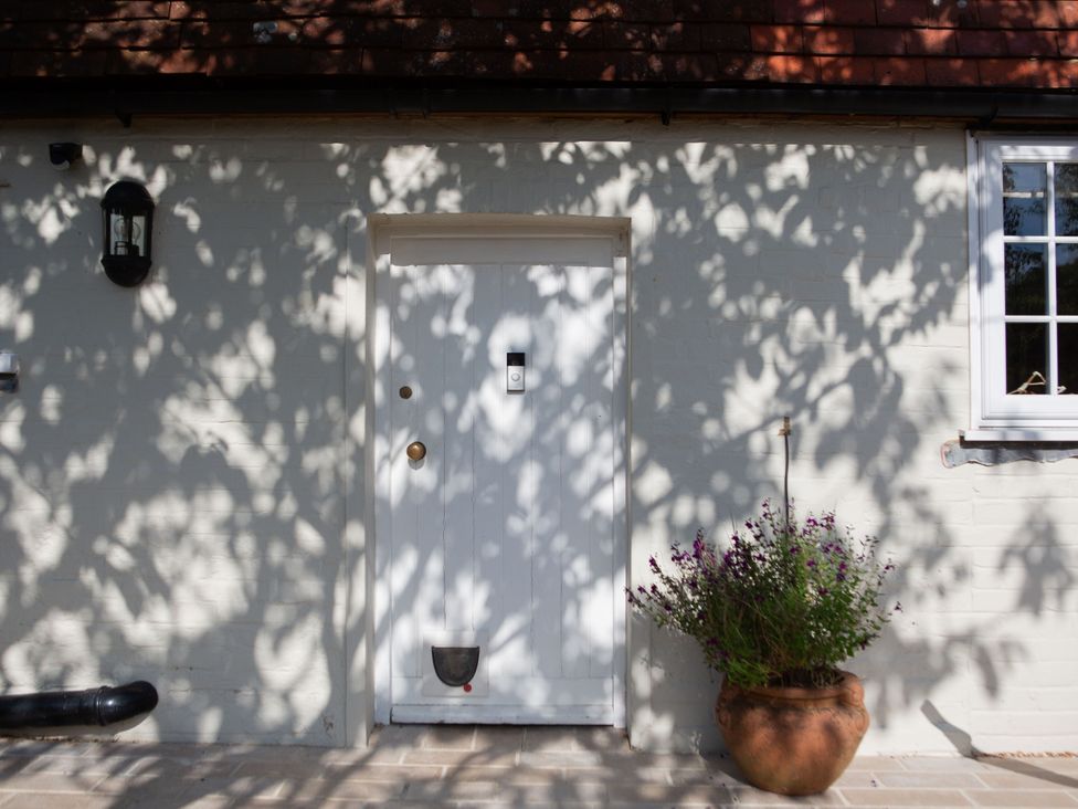 An entrance with a white door and potted plants at Newstead Farmhouse East Chiltington near Lewes, Sussex